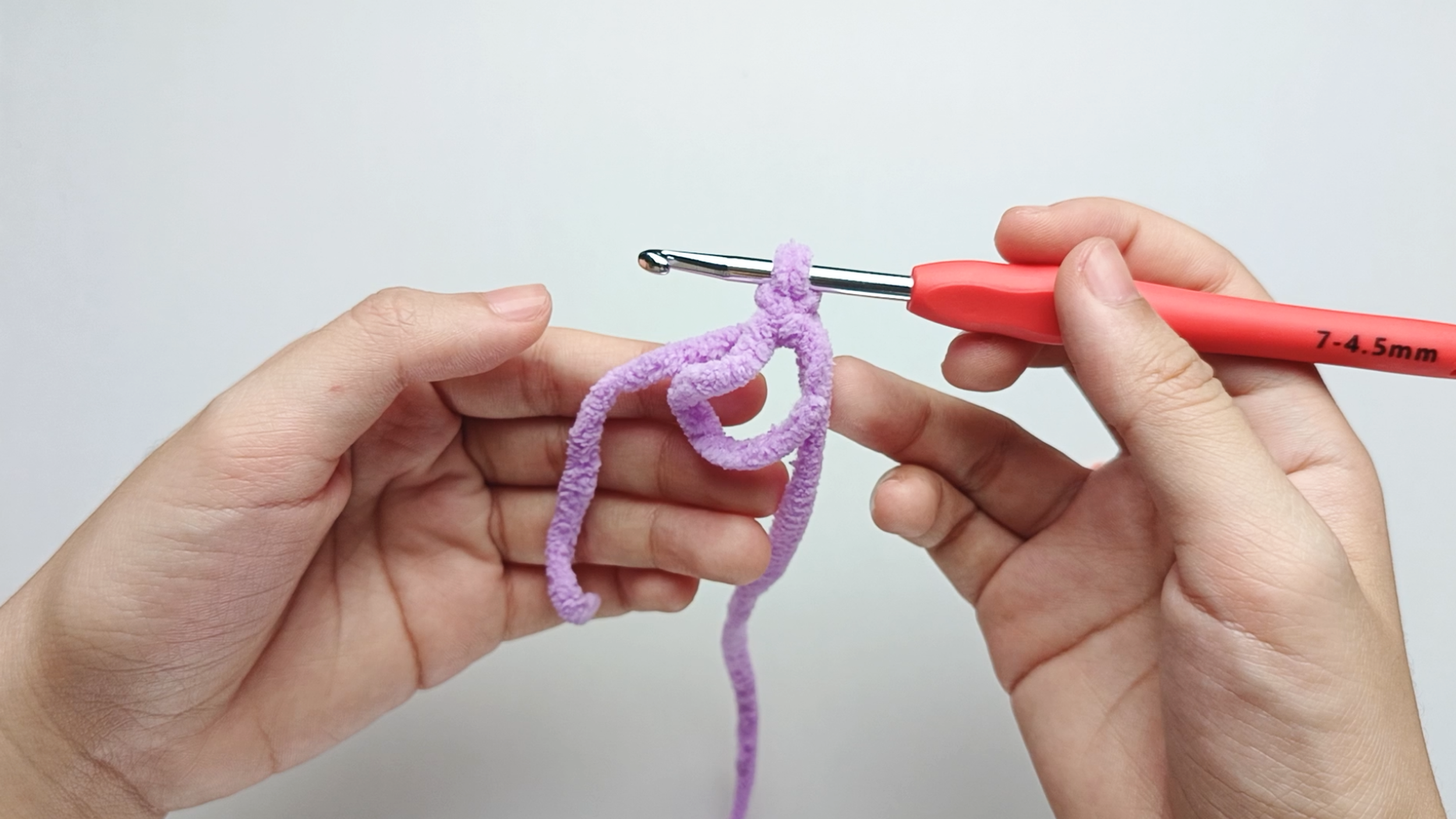 Release the ring: Carefully release the yarn from your left hand. You should now see a small circle of yarn (the ring) with the yarn tail hanging on the left side.