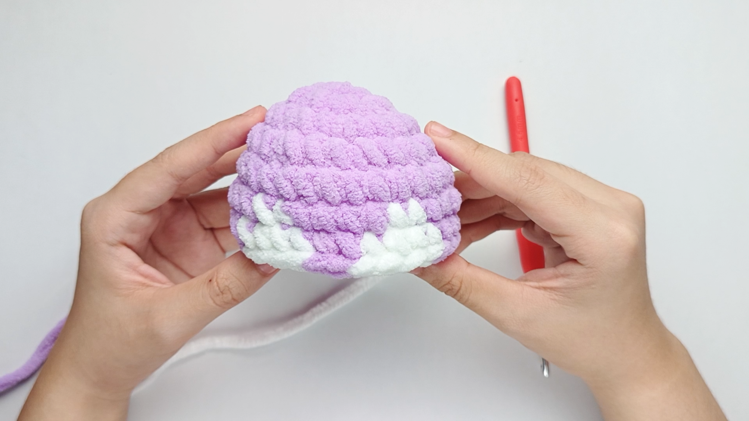 Completed Round 7: Here, we have made single crochets (sc) for 9 purple, 4 white, 2 purple, 4 white, and 9 purple. There should be 28 stitches in total.