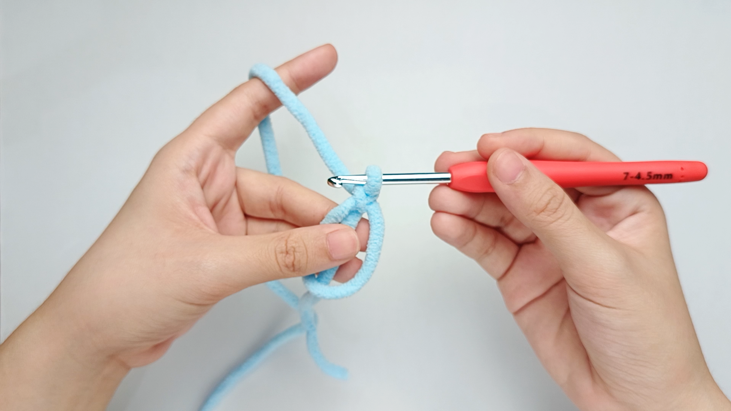 Make a magic ring (MR): Follow the same magic-ring photos from the Body’s Round 1 - from ‘Hold the yarn tail’ through ‘Release the ring’ - to make your magic ring (MR).