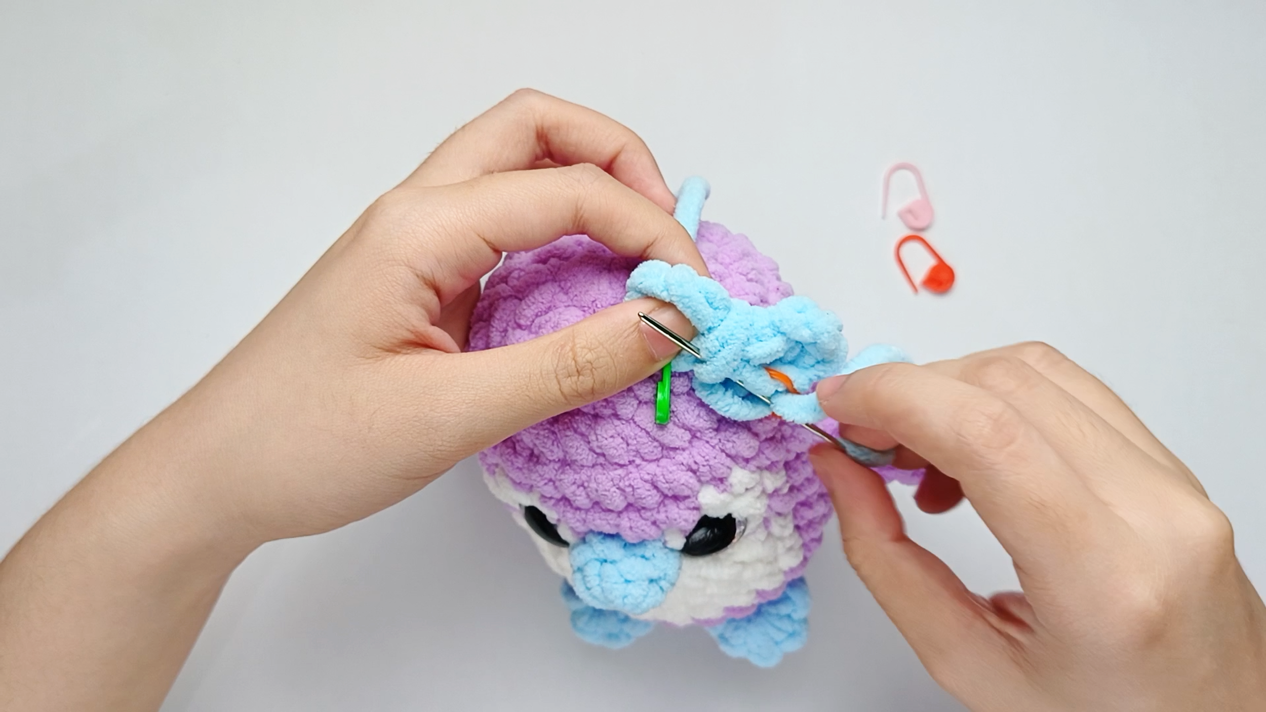 Up through the piece: Bring the needle up through the center of the Bow. Pull the yarn all the way through.