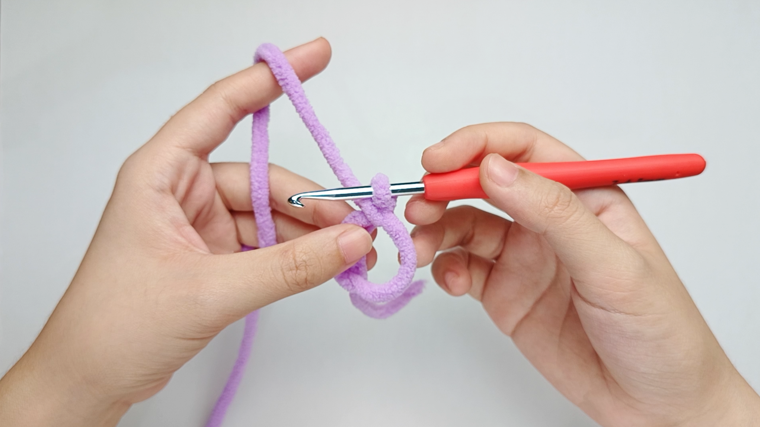 Make a magic ring (MR): Follow the same magic-ring photos from the Body’s Round 1 - from ‘Hold the yarn tail’ through ‘Release the ring’ - to make your magic ring (MR).
