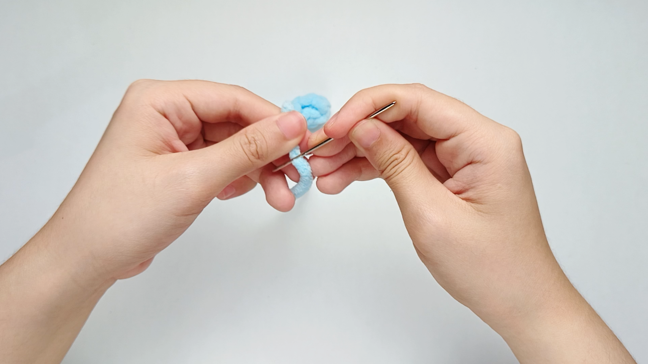Thread the needle: Thread the tail onto your yarn needle.