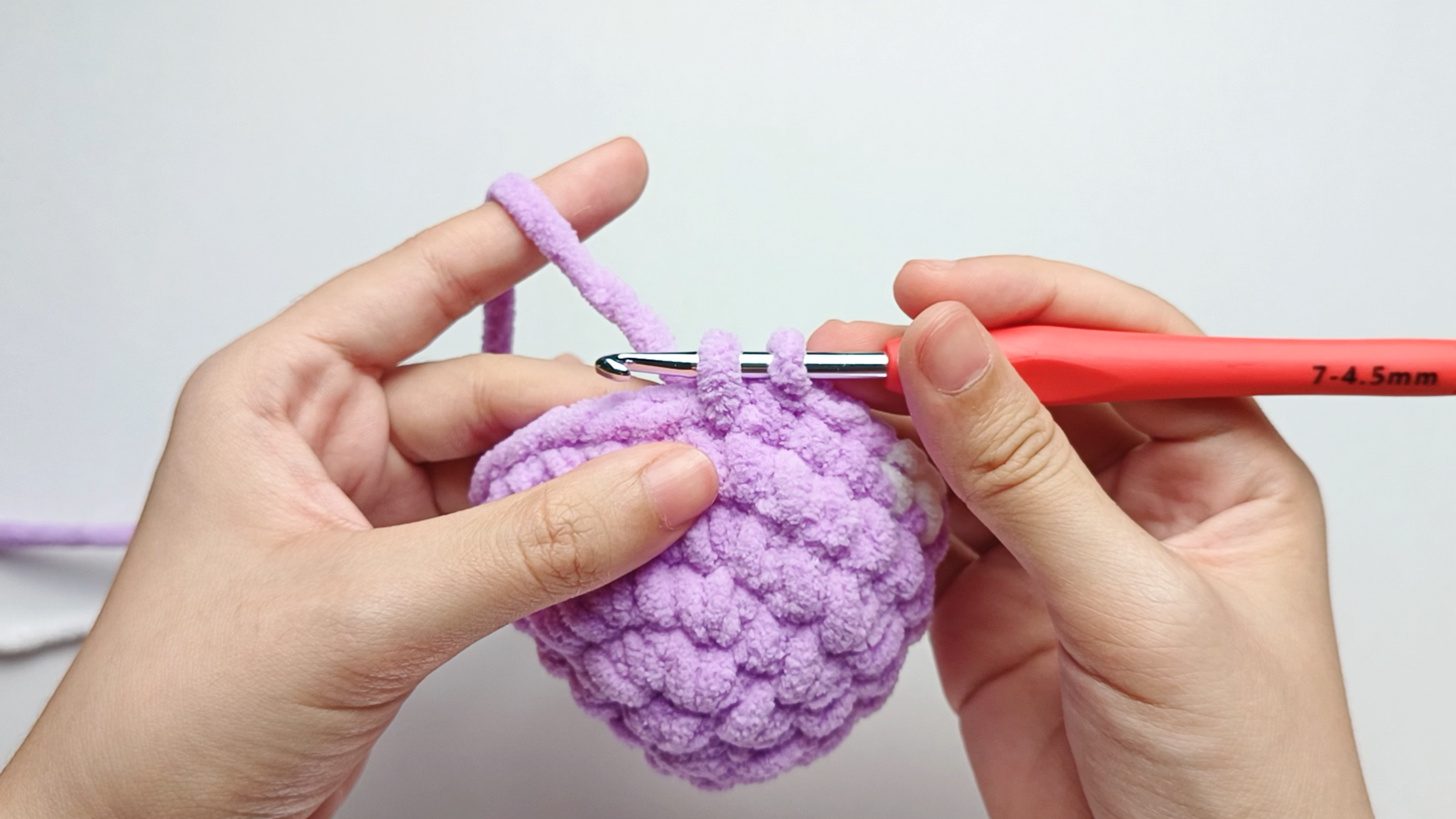Color change to purple: Drape the purple yarn over your hook and pull it through to switch colors, just like you did with white earlier. Make 4 purple single crochets (sc), and stop just before the final yarn over.