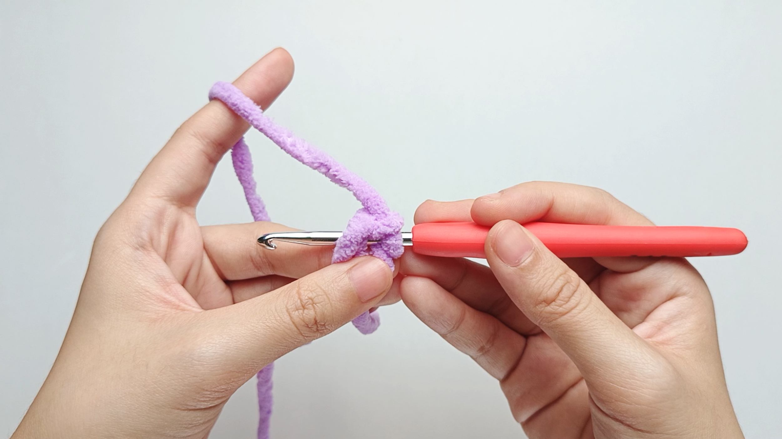 Hook into the ring: Insert your crochet hook through the center of the ring from right to left, going under both strands of the loop.