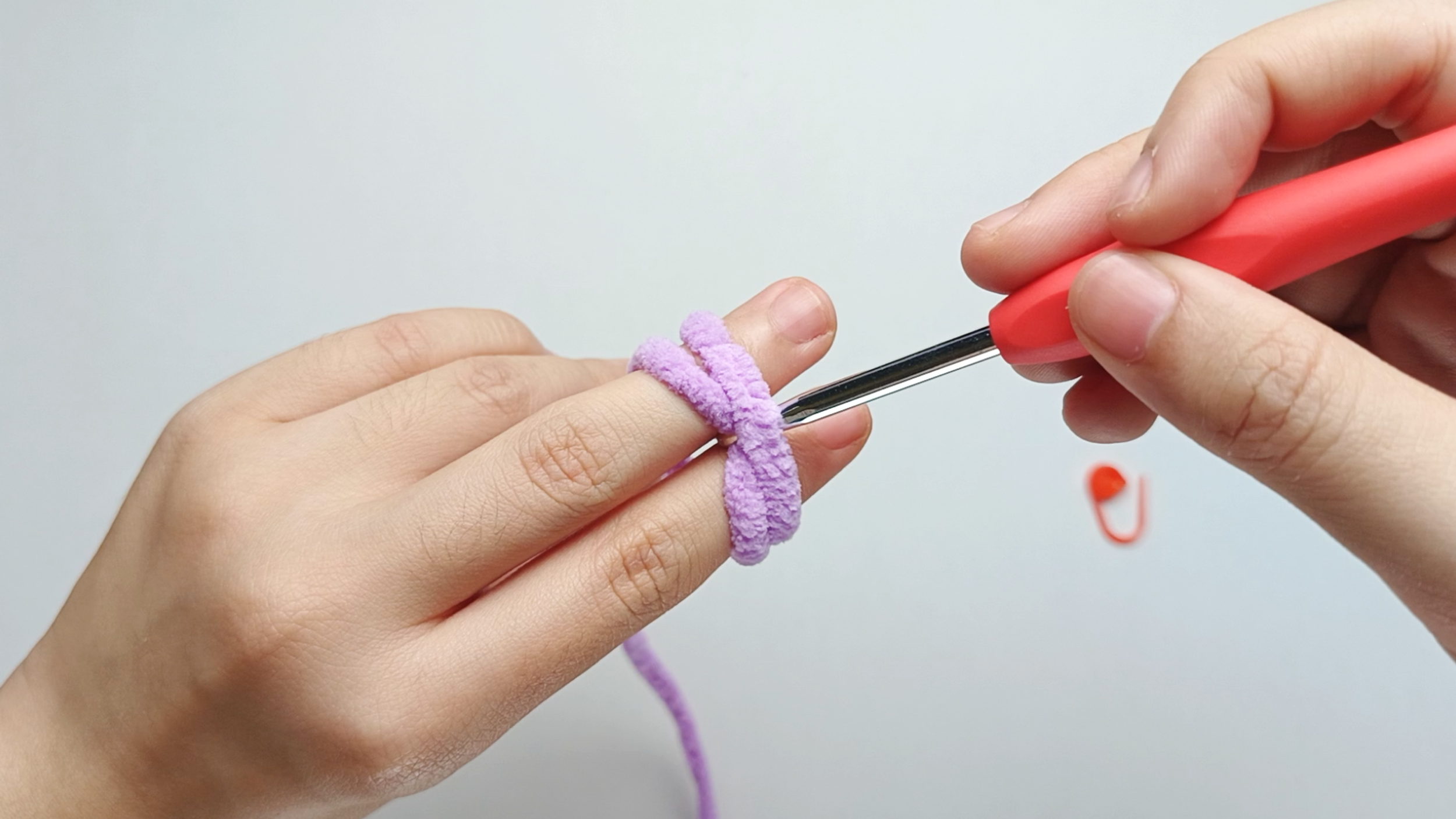 Pull through: Use the hook to pull the second strand underneath the first.