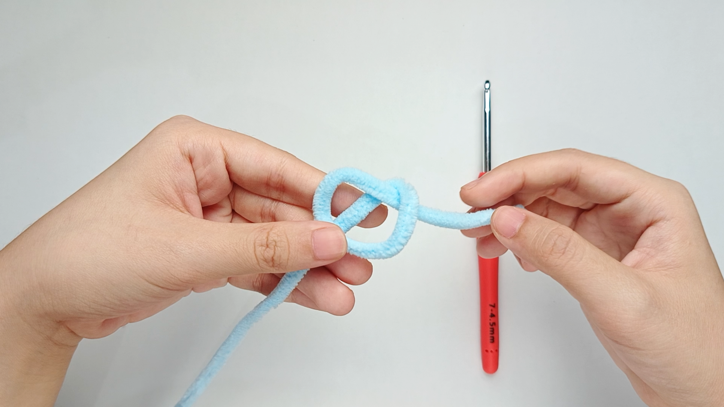 Fold the loop over: Fold the loop to one side, keeping the working yarn running through the middle.