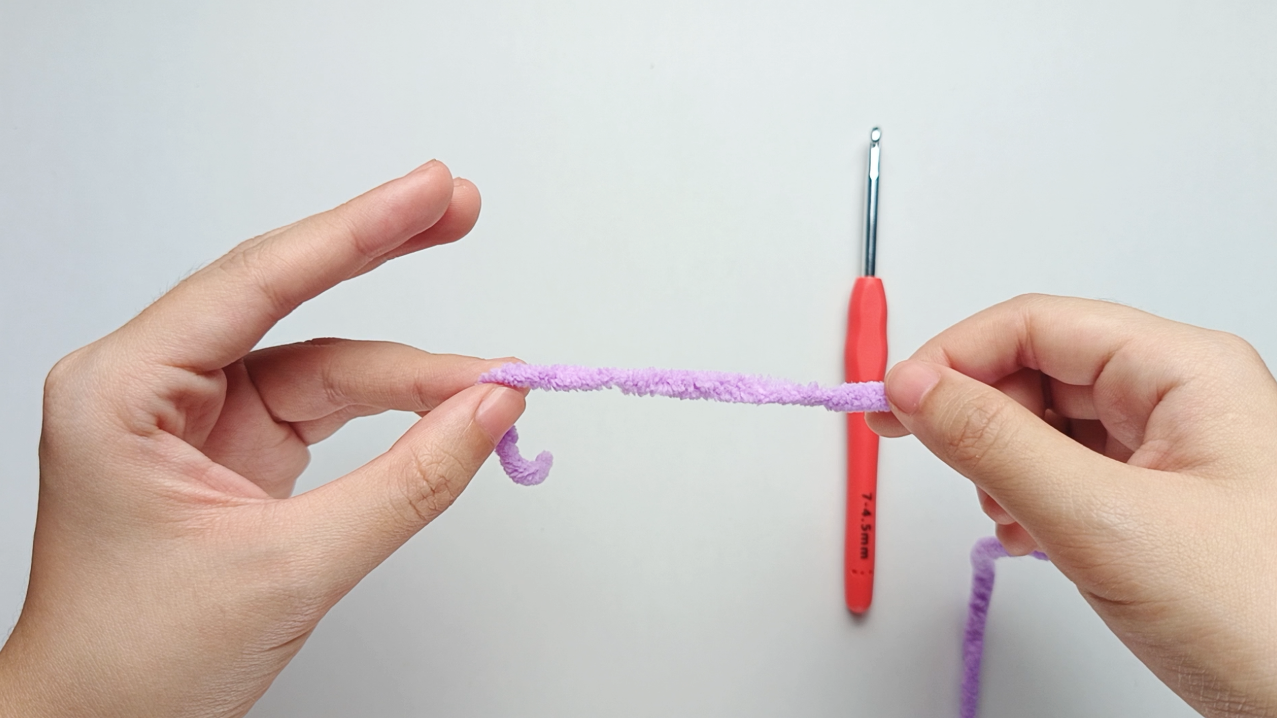 Hold the yarn tail: Hold the yarn tail with the ring finger and thumb of your left hand, and hold the working yarn in your right hand.