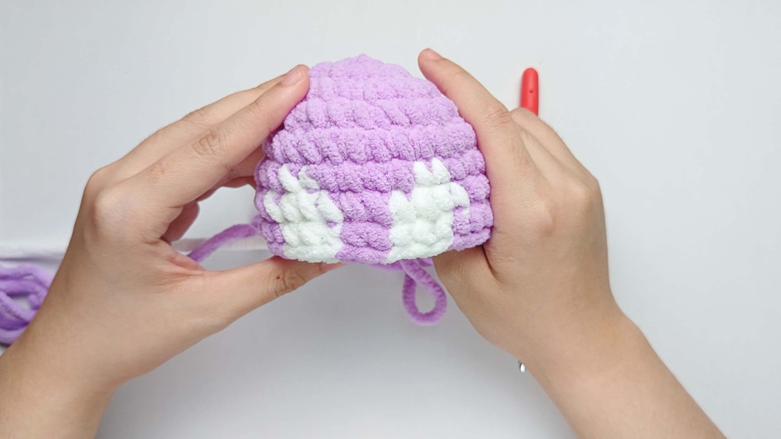 Completed Round 8: Here, we have made single crochets (sc) for 10 purple, 3 white, 2 purple, 3 white, and 10 purple. There should be 28 stitches in total.