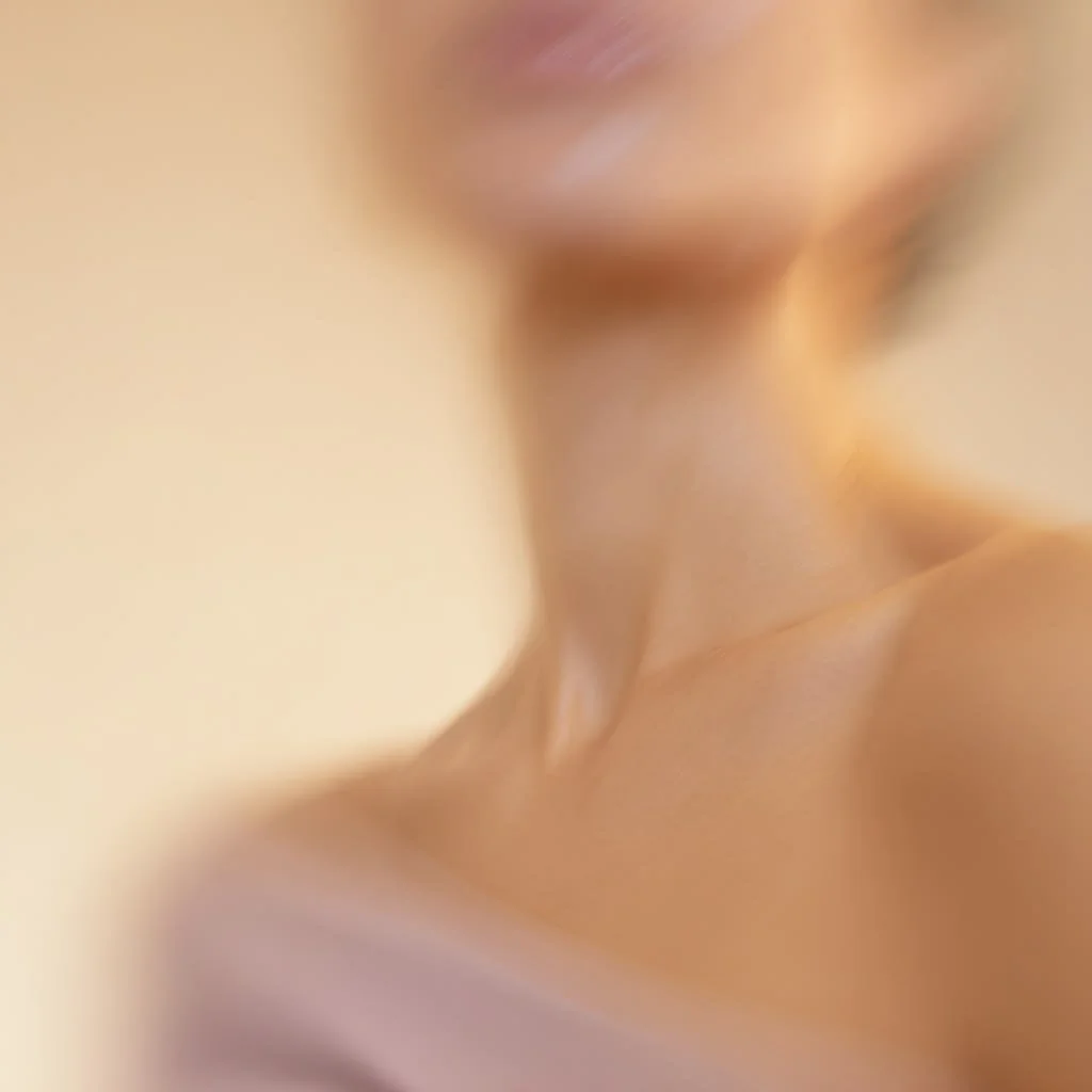 A close-up, blurry photo of a person's neck, shoulder, and lips with a neutral background.