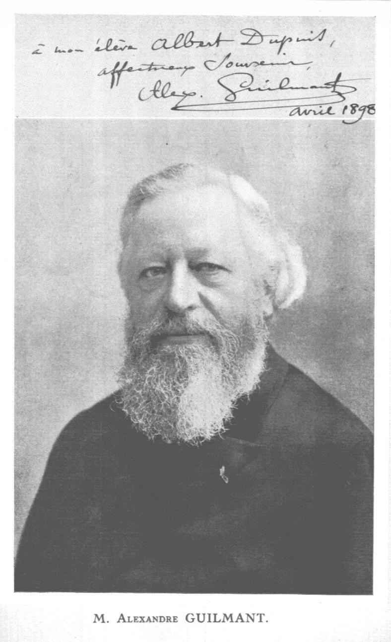 Black and white portrait photograph of an older man with a full white beard and mustache, wearing a dark coat. Handwritten note at the top with a signature and date indicating April 1898, dedicated to an individual named Albert Dupuist from Cloy. Squire.