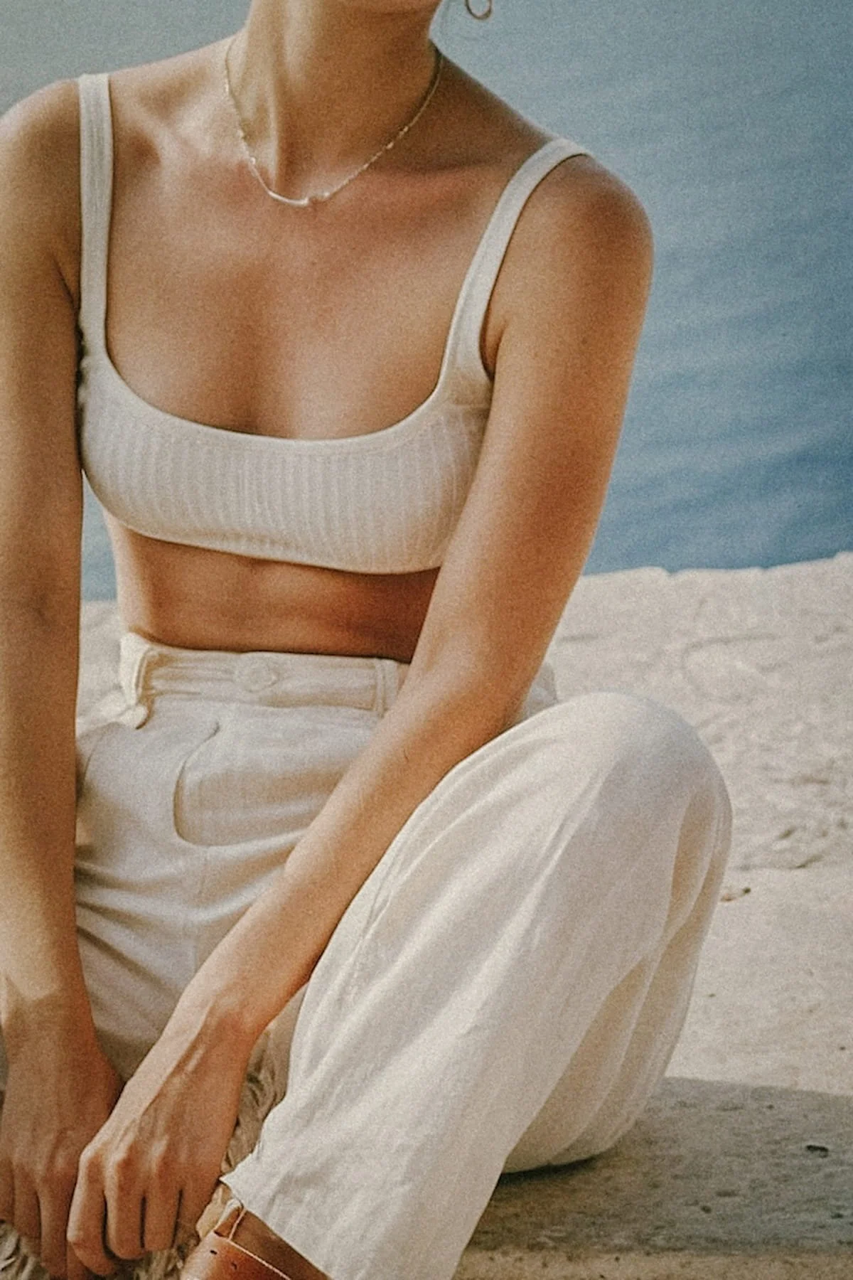 A woman seated in quiet contemplation wearing neutral linen, representing the 1:1 Private Residency format for total solitude.