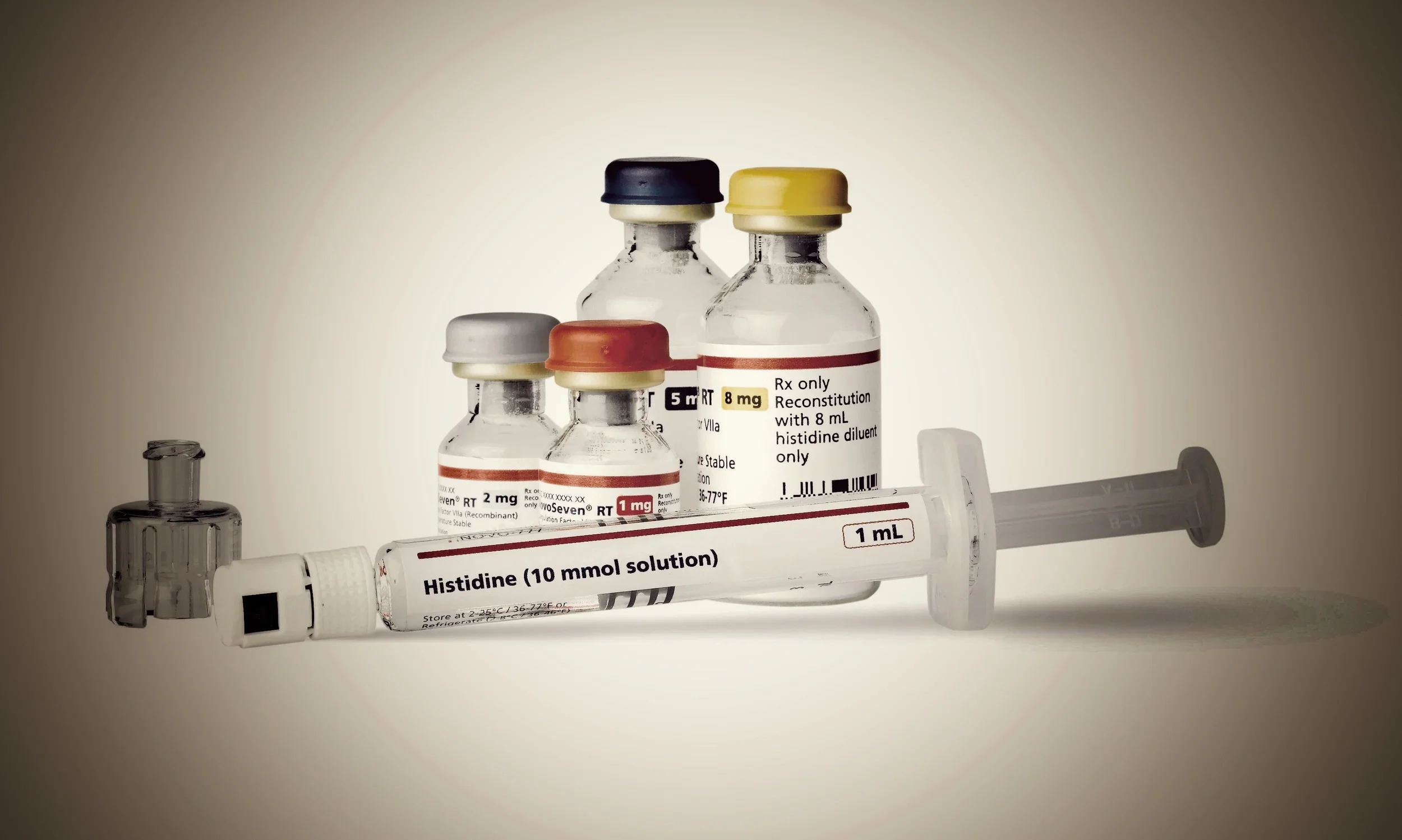 Medicinske sprøjter og medicinflasker med etiketter, der angiver histidinløsning og andre medicinske stoffer på en operationsbord.