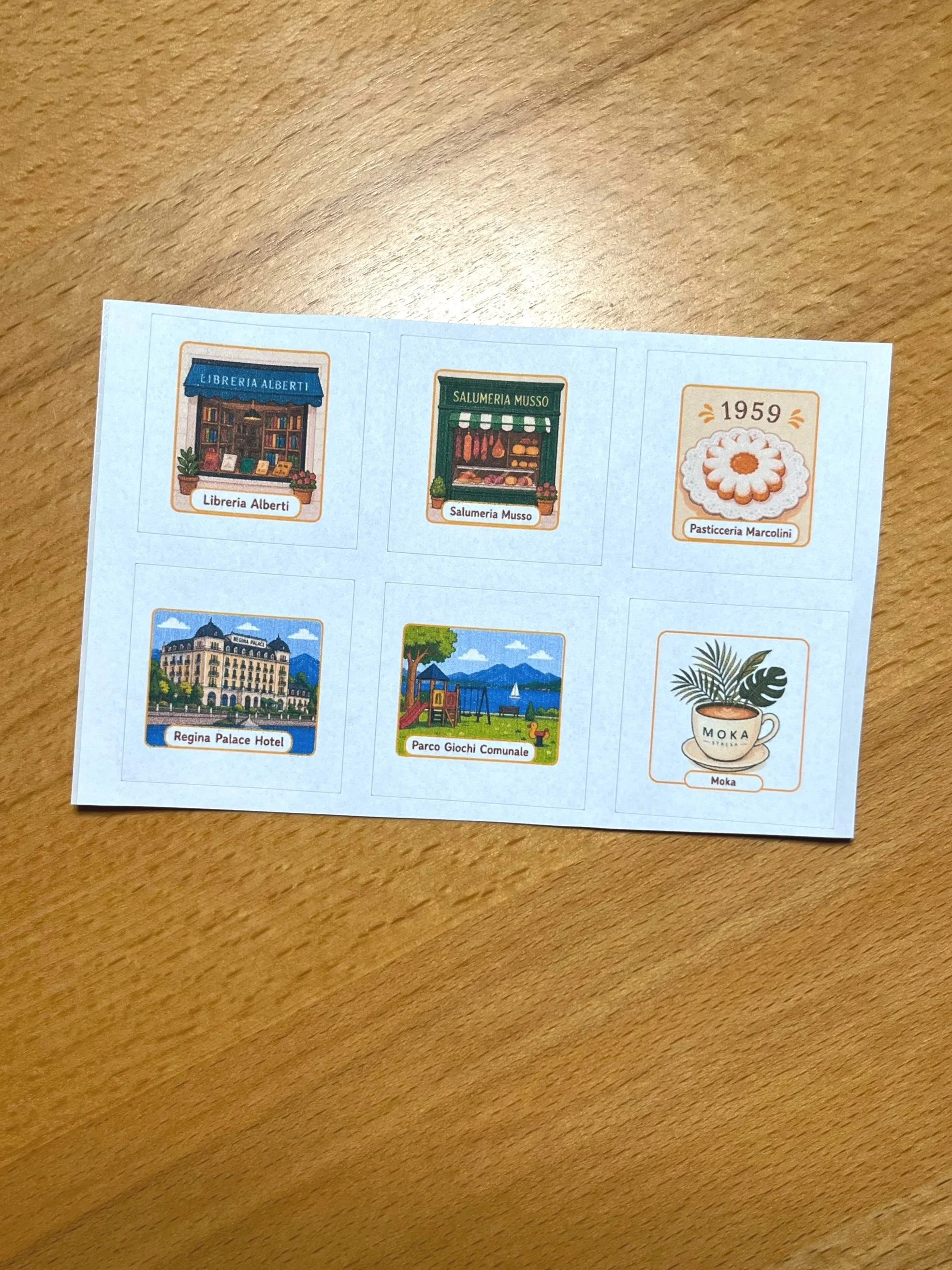 Stresa scavenger hunt sticker sheet showing six illustrated stops including Libreria Alberti, Salumeria Musso, and Regina Palace Hotel — Small Steps Explorers