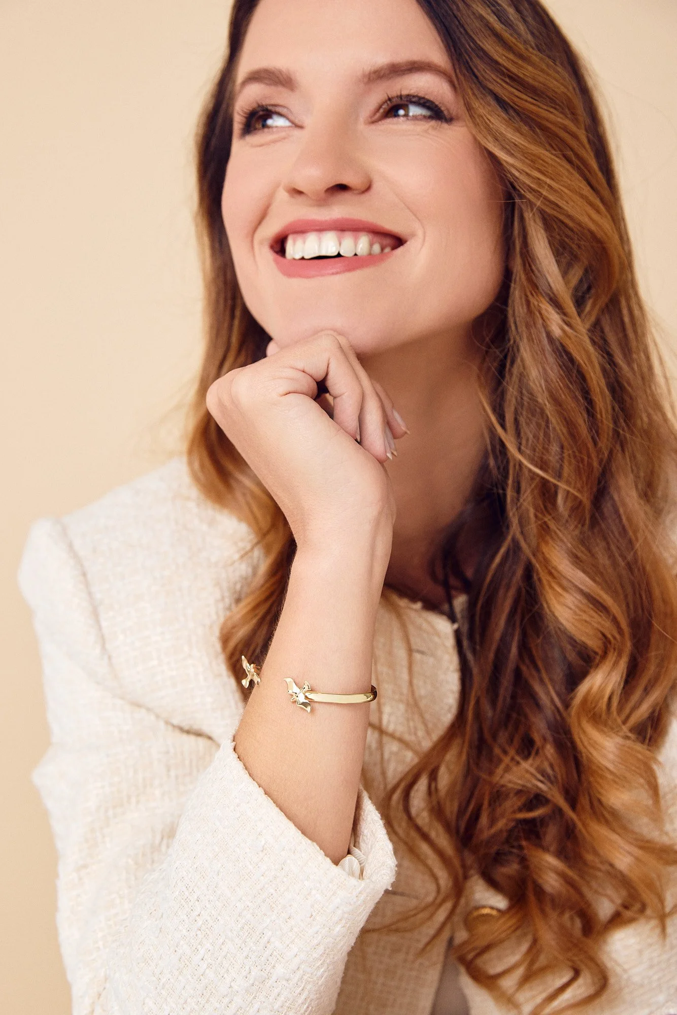 Close-up of a woman with long, wavy red hair smiling.