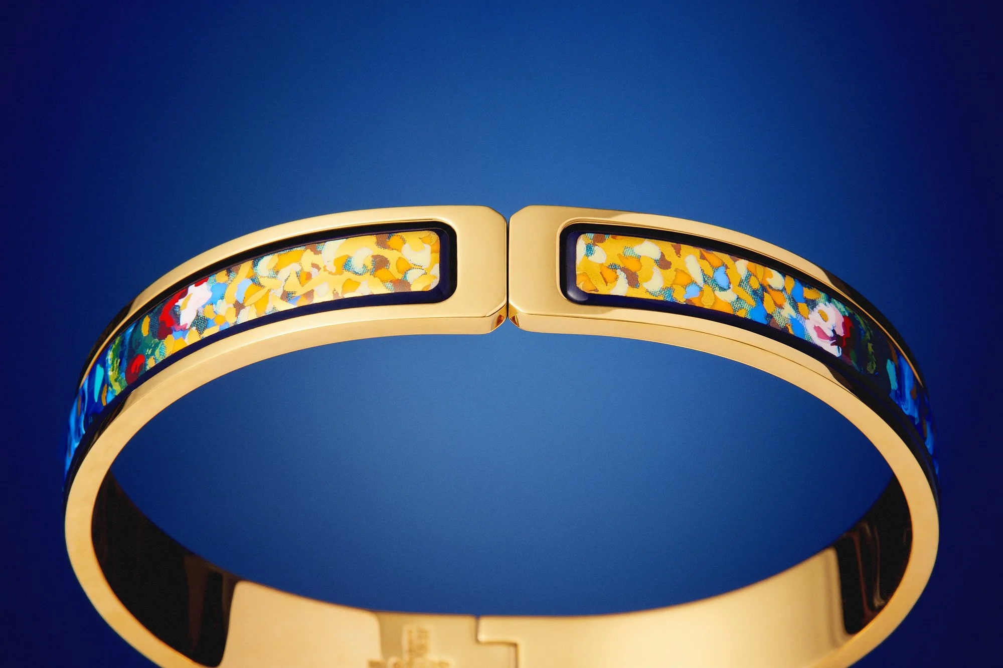 Close-up of a futuristic gold-colored Frey Wille clasp against a dark background.