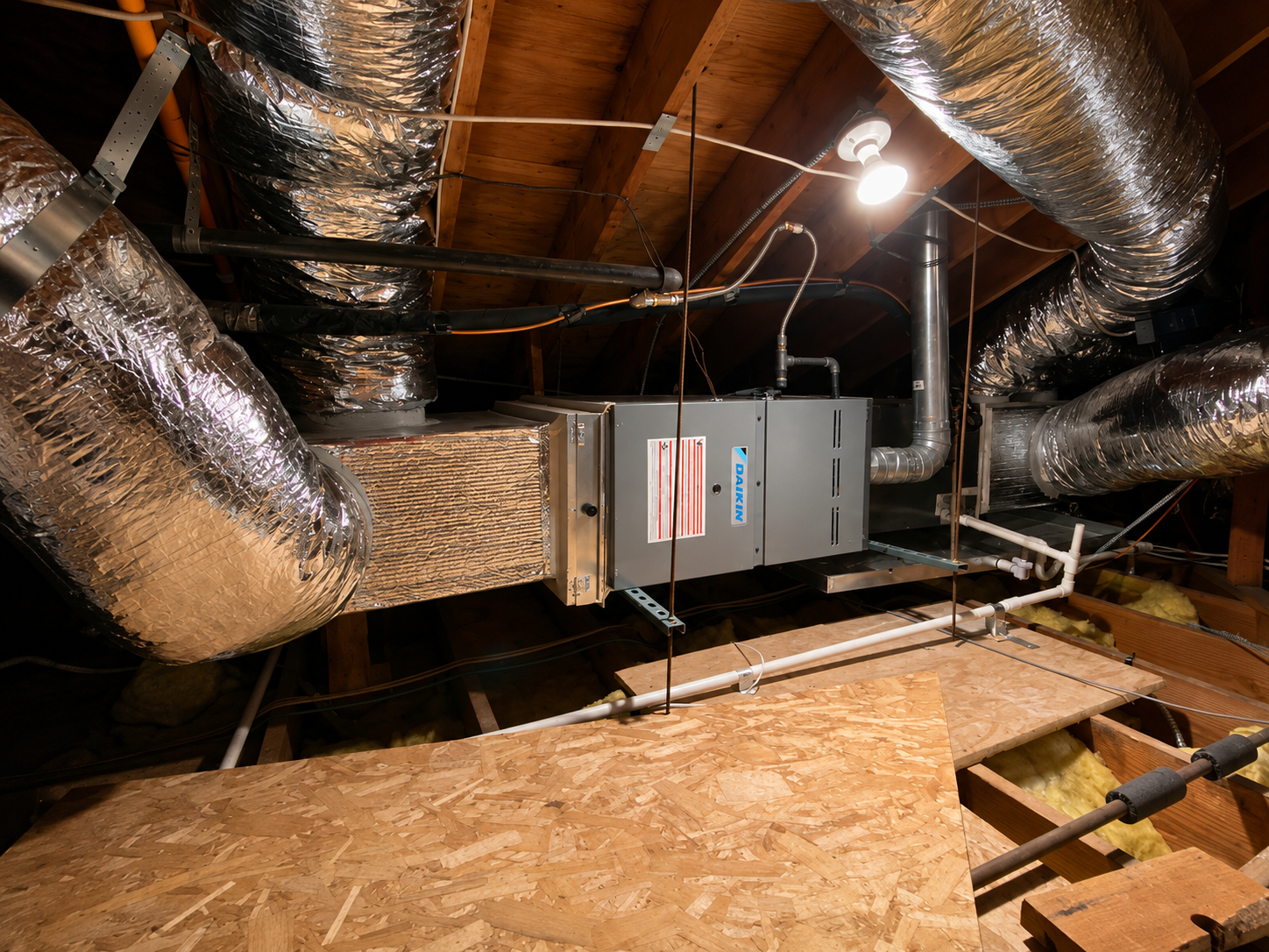 Residential HVAC system professionally installed in an attic with insulated ductwork.