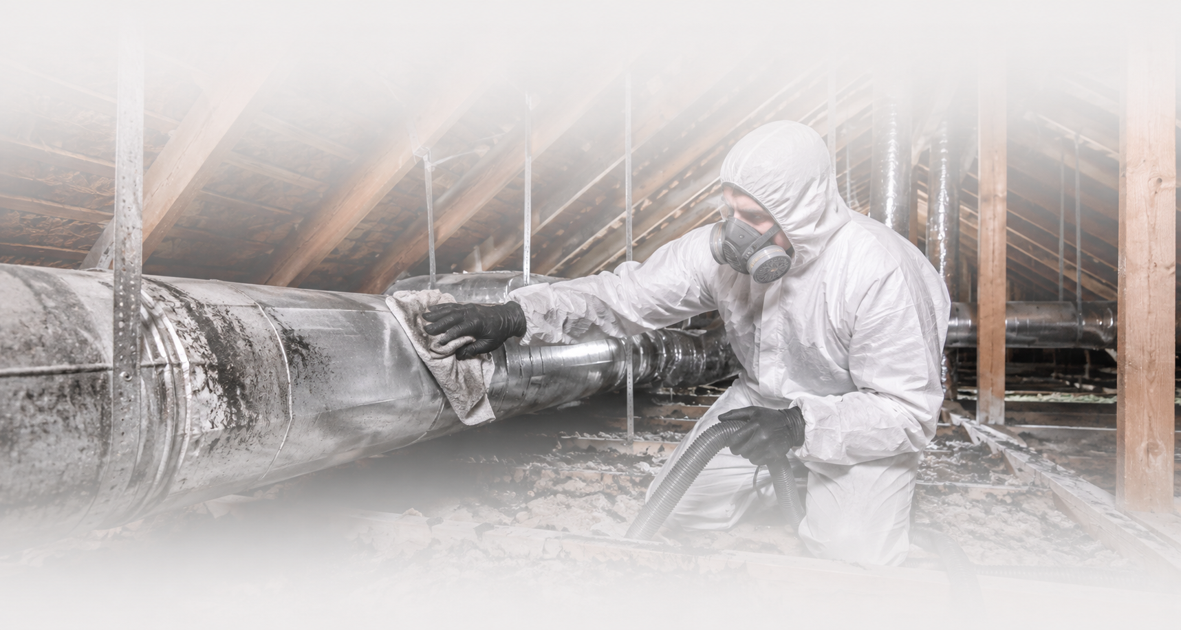 Technician cleaning smoke, soot, and ash contamination from residential attic ductwork after fire damage.
