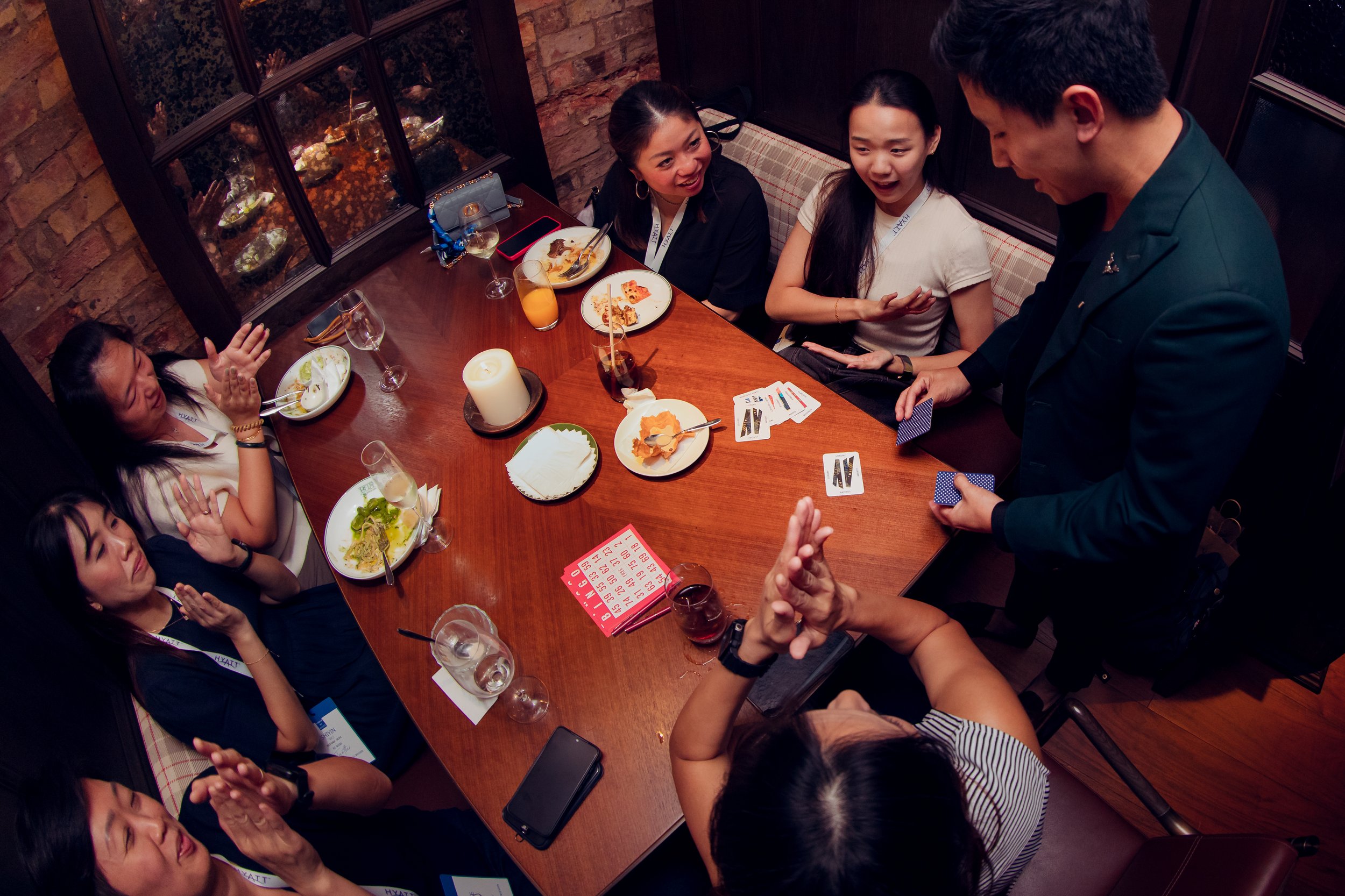 Jerryl Tan, showcasing his magic trip at a close up table event with his audience.