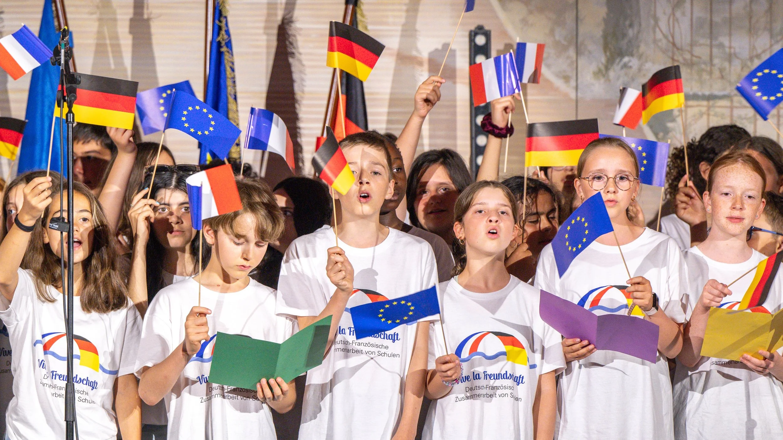 Kinder und Jugendliche feiern die Deutsch Französische Freundschaft, mit Fahnen aus Frankreich, Deutschland und Europa