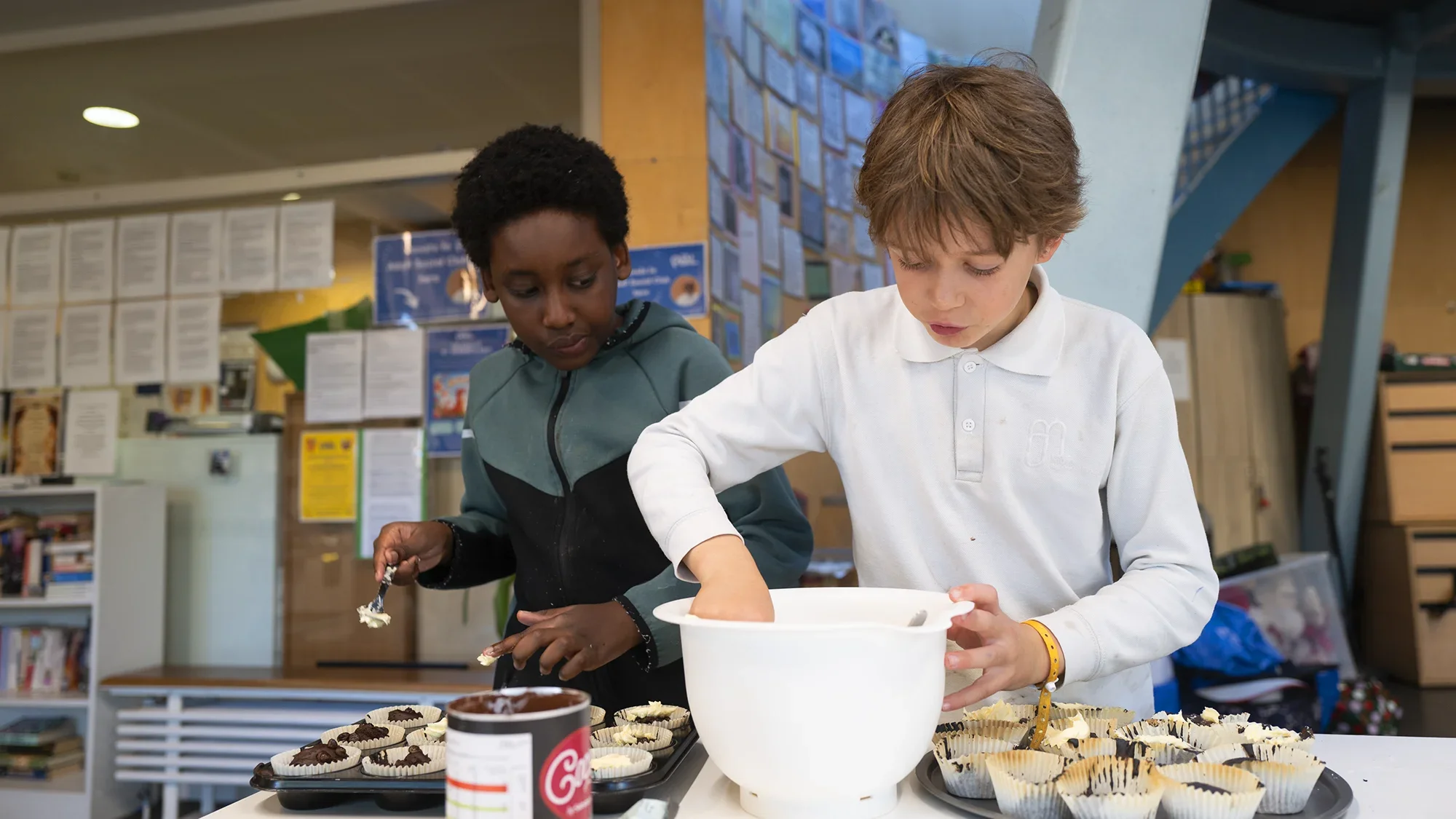 Two boys preparing cupcakes
