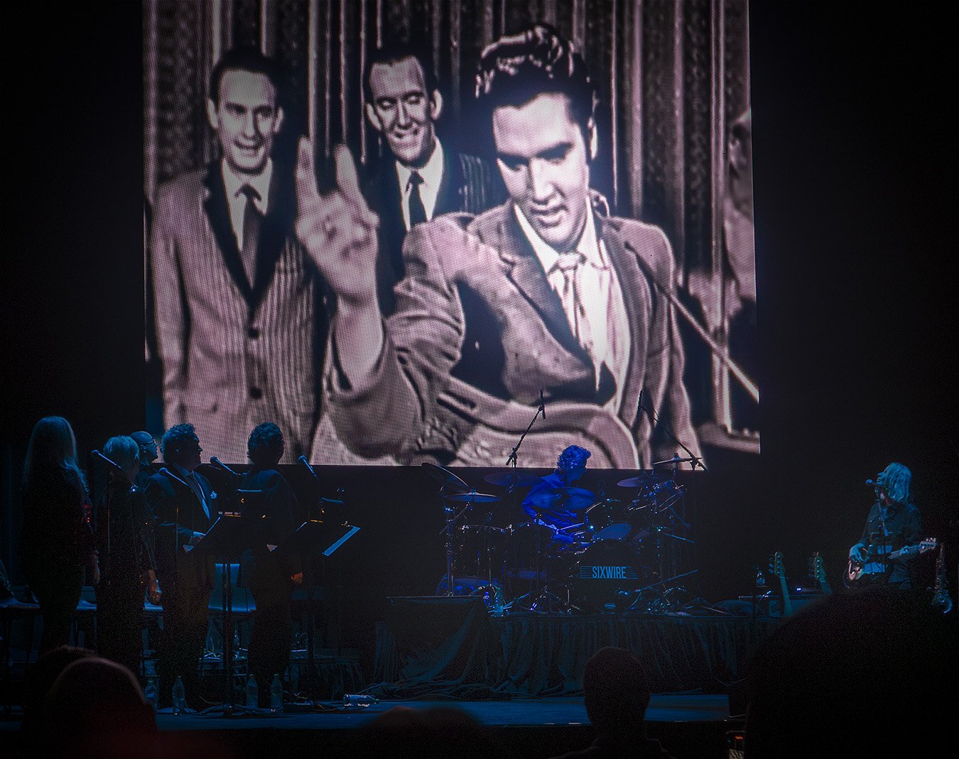Elvis Live on Stage – 90th Birthday Concert at Graceland, Memphis, TN, 2025. Video footage and Elvis’s original voice from a 1950s TV performance, accompanied by a live orchestra and backing vocals from the stage.
