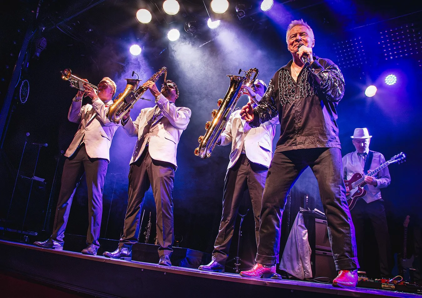 Jerry Williams performing alongside the horn section during an energetic live show in Stockholm, Sweden, 2016.
