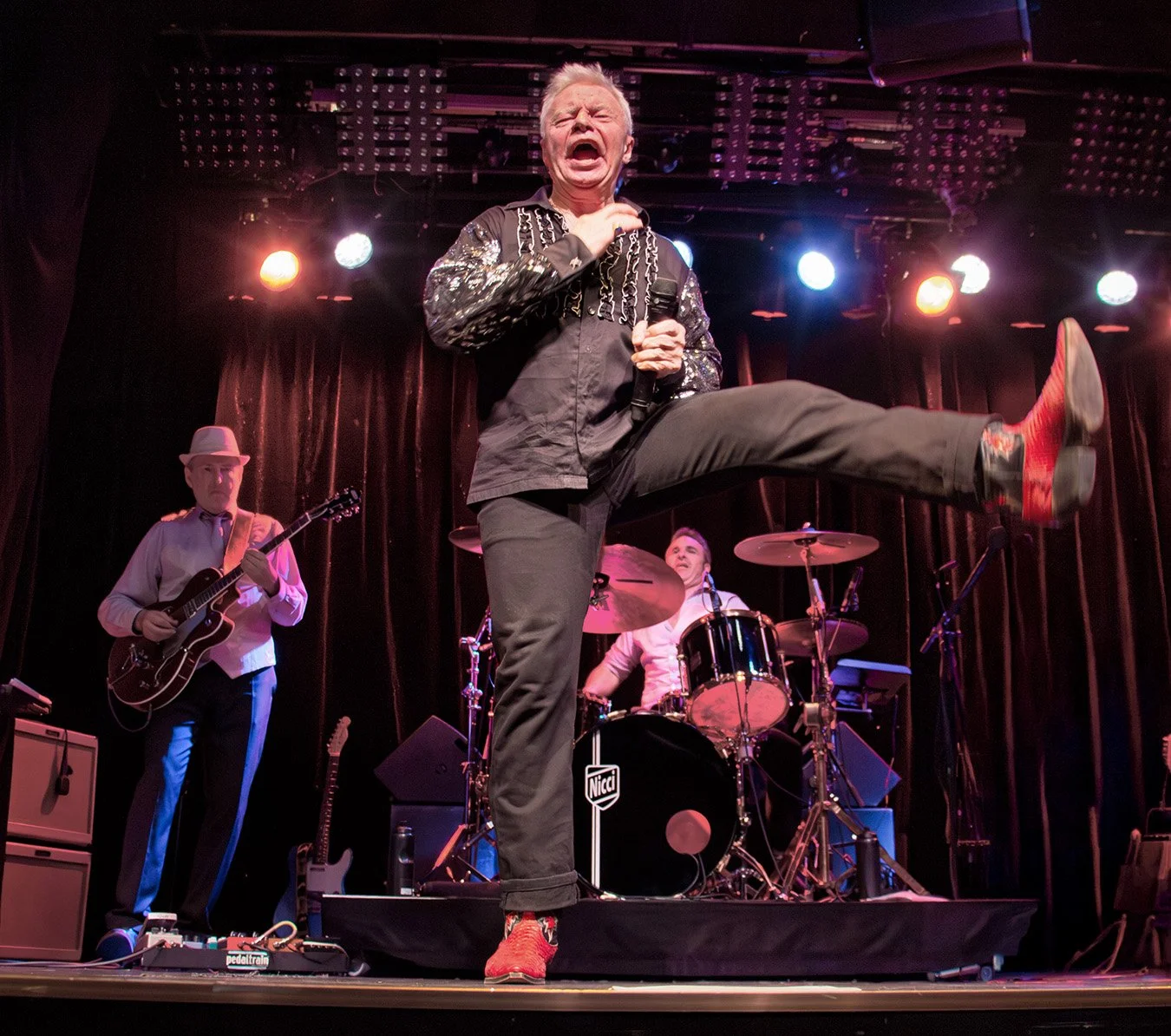 Jerry Williams performing energetically on stage during a live concert in Stockholm, Sweden, 2016.