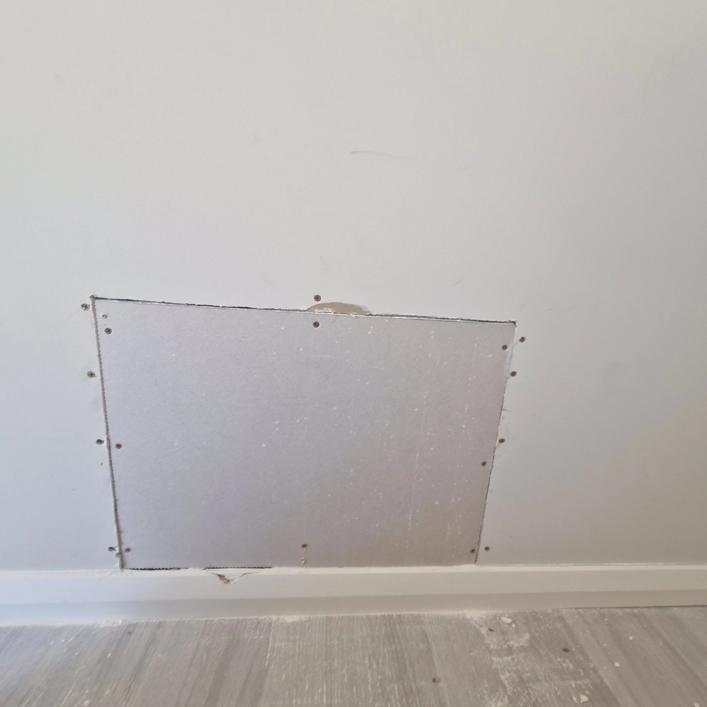 a picture of a drywall patch that has been cut out correctly ready for plaster compound
