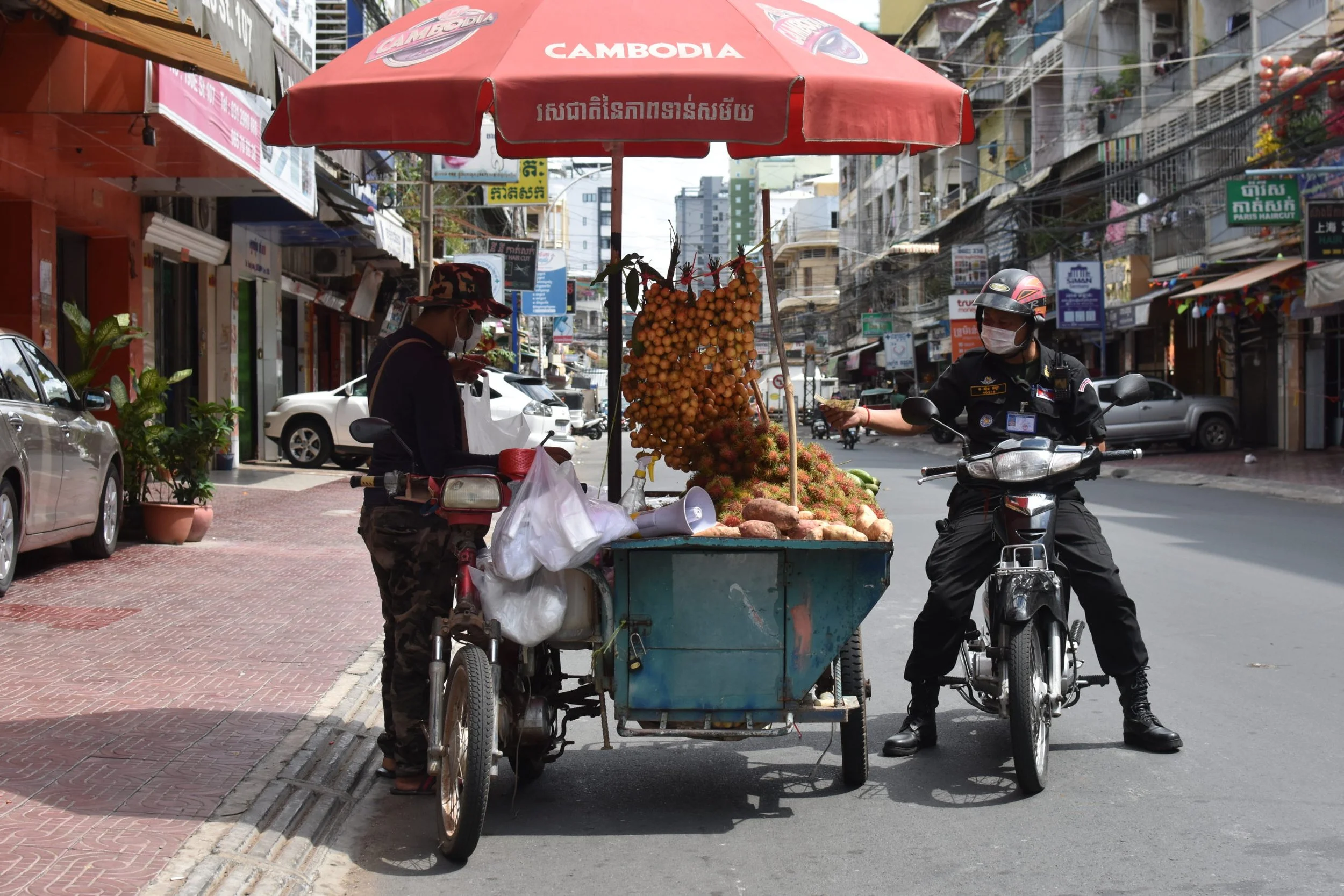 A police officer buys food during a COVID-19 lockdown in Phnom Penh, Cambodia. Southeast Asia Globe, April 2021. 