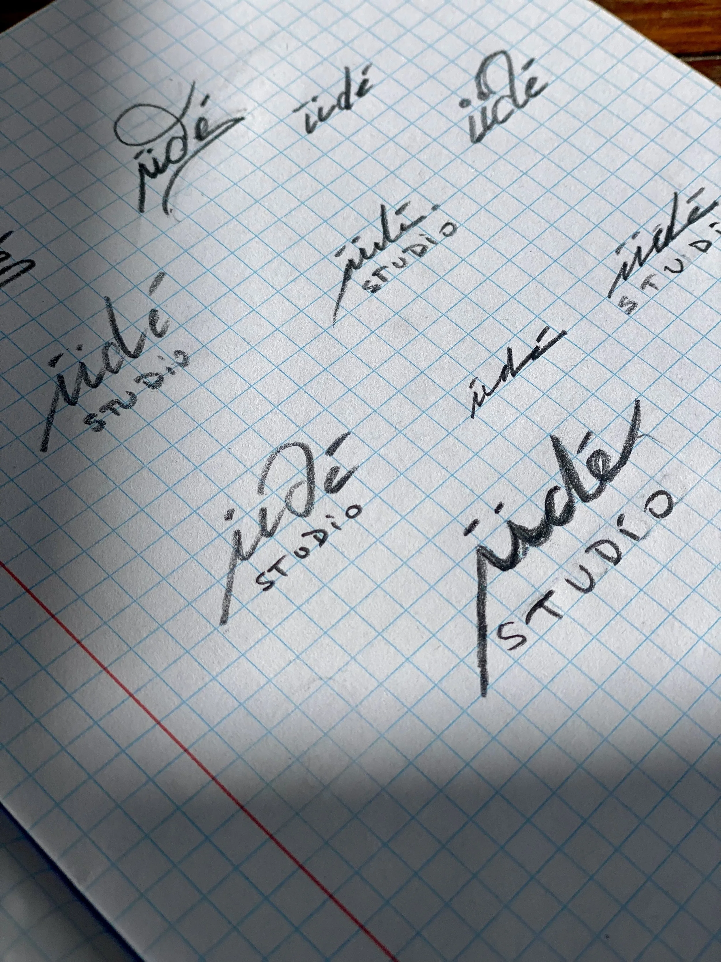 Page de notes écrites à la main sur du papier quadrillé, avec différents mots en français tels que 'idéale', 'étiquette', 'indé' et 'titres'.