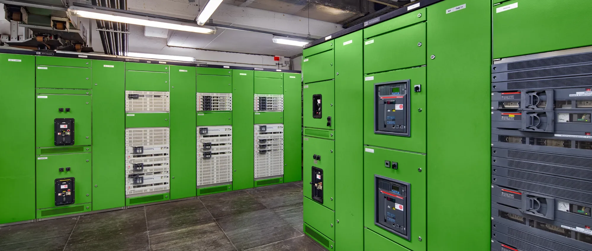 Blick auf grüne Schalttafeln in einem technischen Raum.