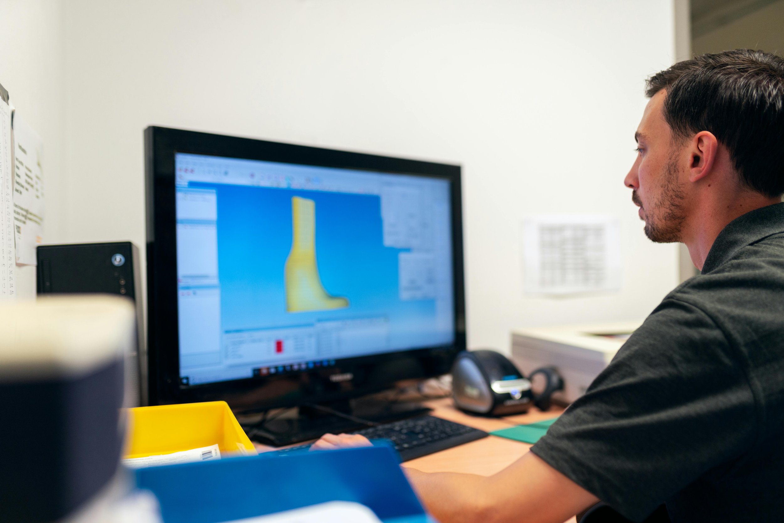 Engineer reviewing a 3D part model on a desktop screen