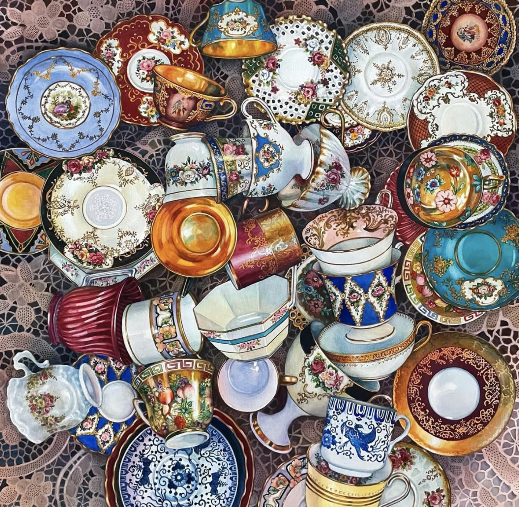 A collection of decorative porcelain and ceramic cups, saucers, and plates with intricate floral patterns and vibrant colors, arranged on a lace tablecloth.
