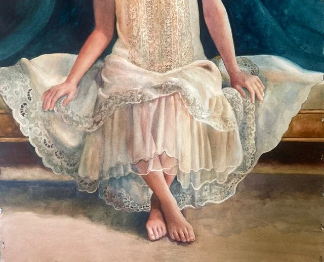 Close-up of a woman sitting on a bench, wearing a vintage lace and silk dress, with bare feet resting on the floor.
