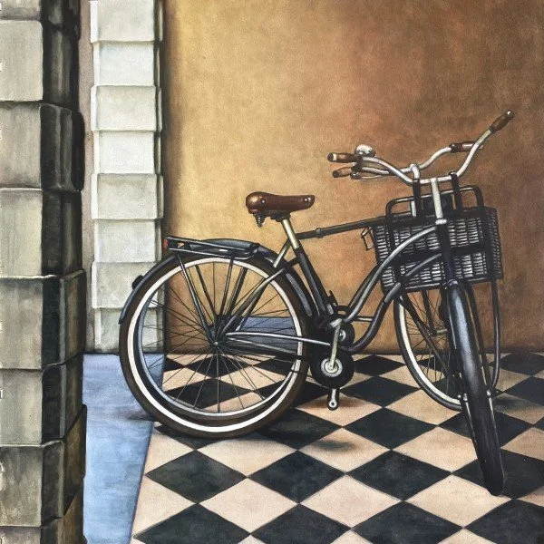 A vintage black bicycle with a front basket, parked on a black and white checkered tile floor indoors.