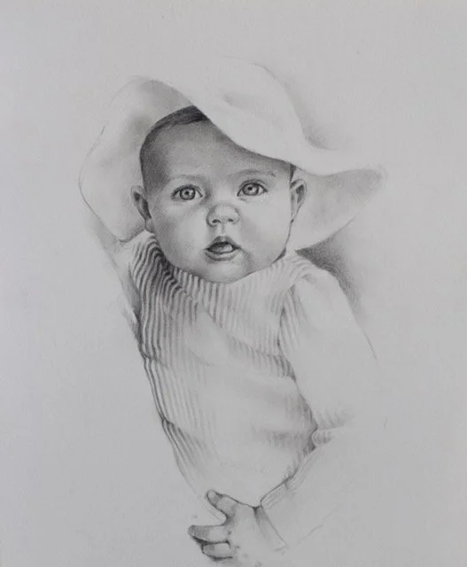 A realistic pencil drawing of a young child wearing a wide-brimmed hat and a striped shirt.
