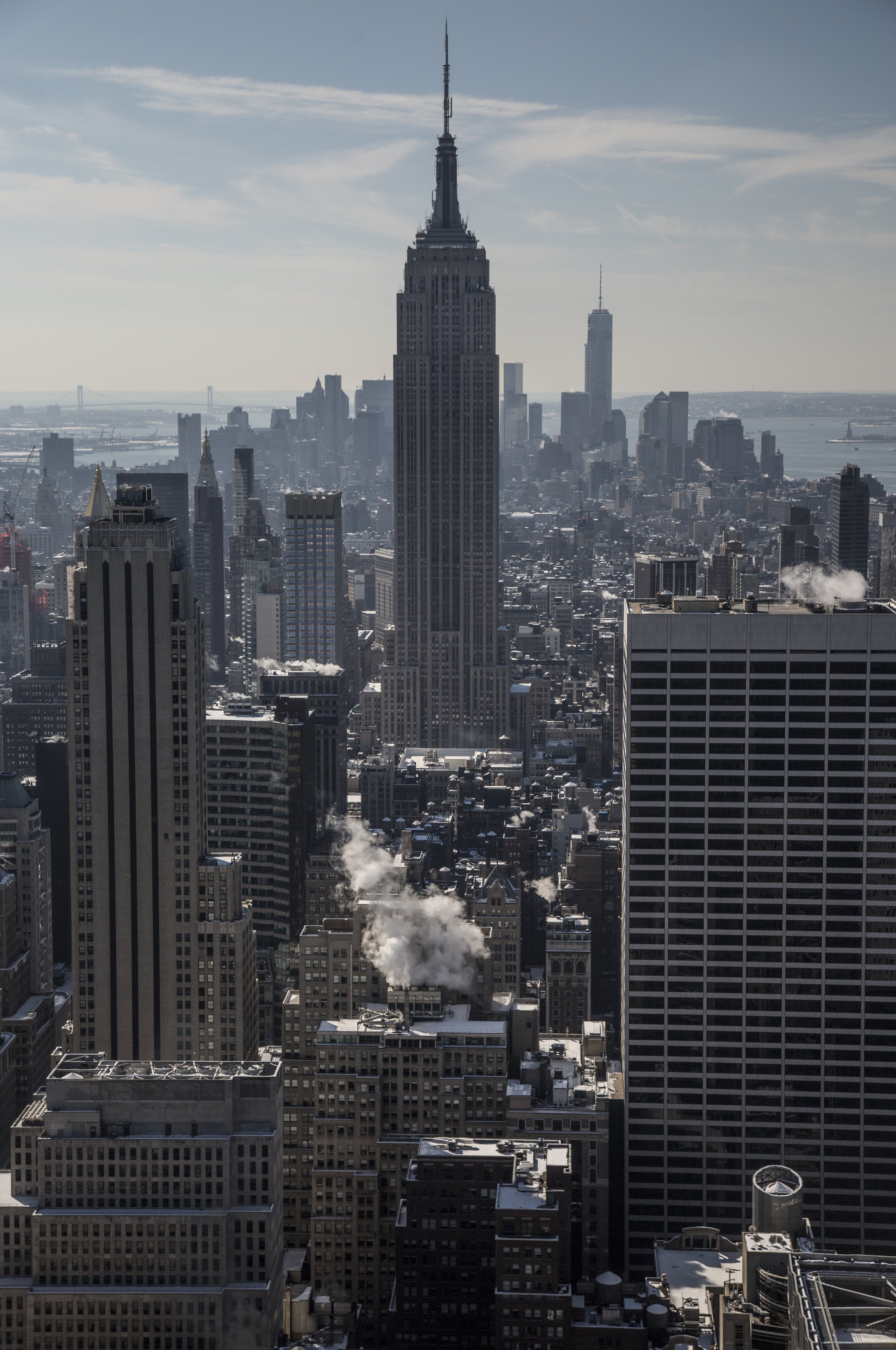 Photo de la skyline de New York avec l'Empire State Building au centre, d'autres gratte-ciel et le fleuve à l'arrière-plan.
