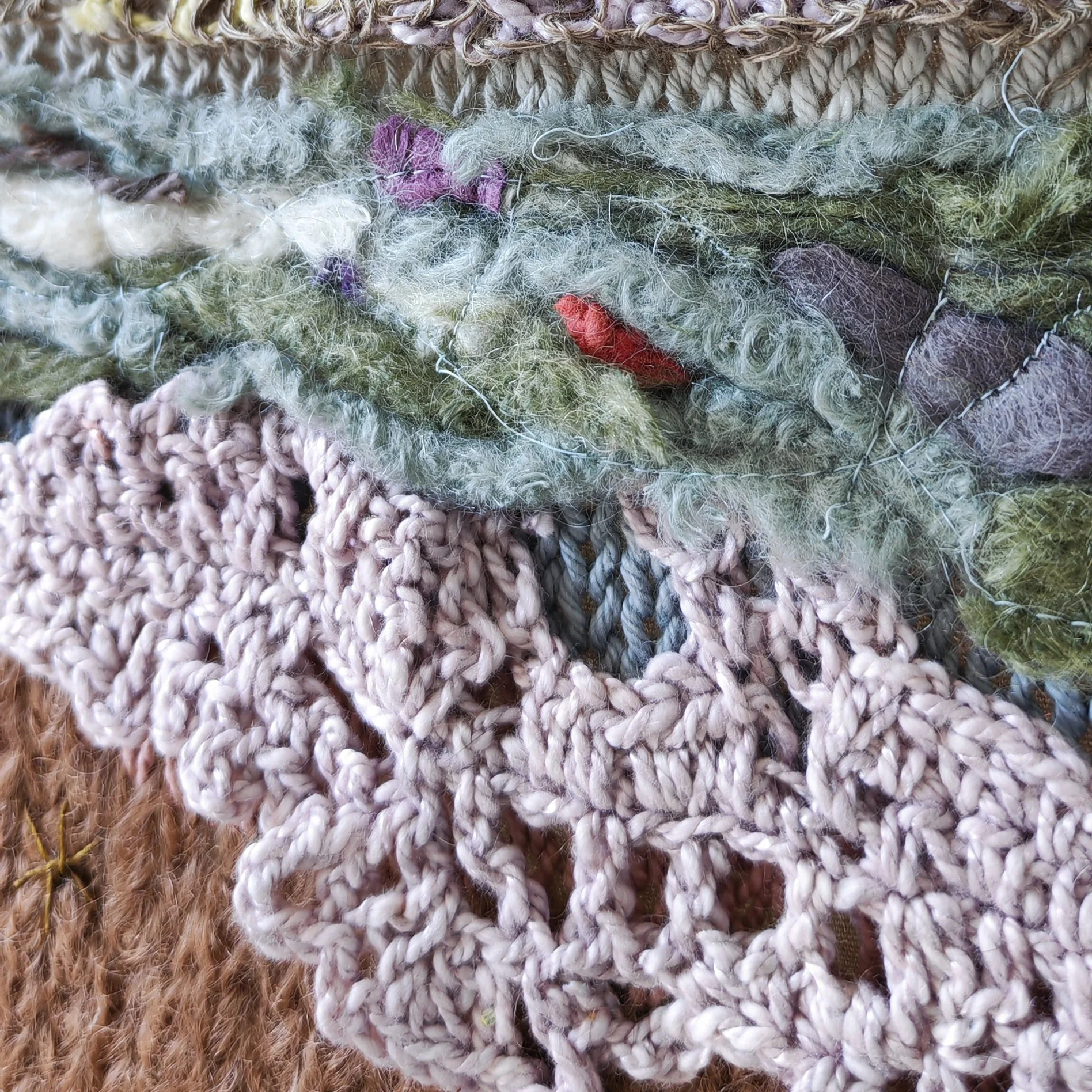 Close-up of a textile art wall panel showing hand and machine knitting, crochet elements, beads and felting.