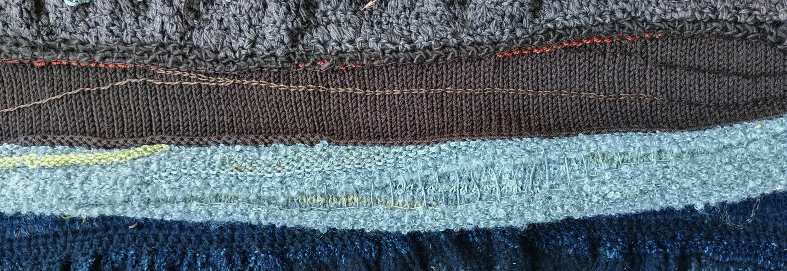 Close-up of the layers in a textile art wall hanging, showing different textures, colours and techniques.