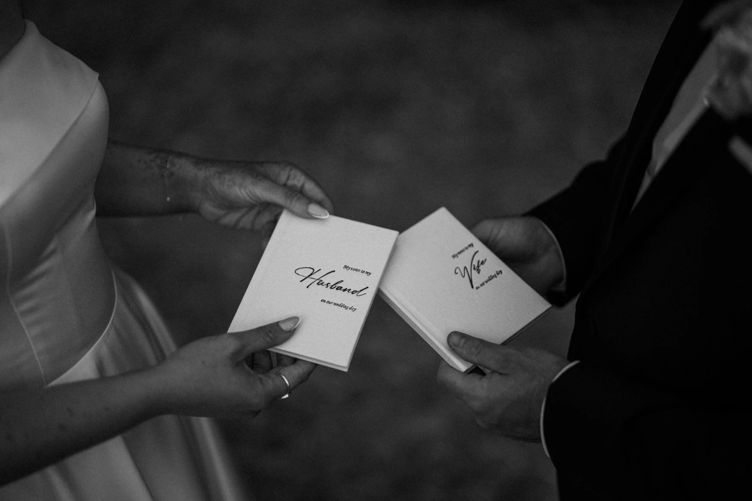 Two people exchanging wedding cards at a church or wedding venue, one person is handing a card to another.
