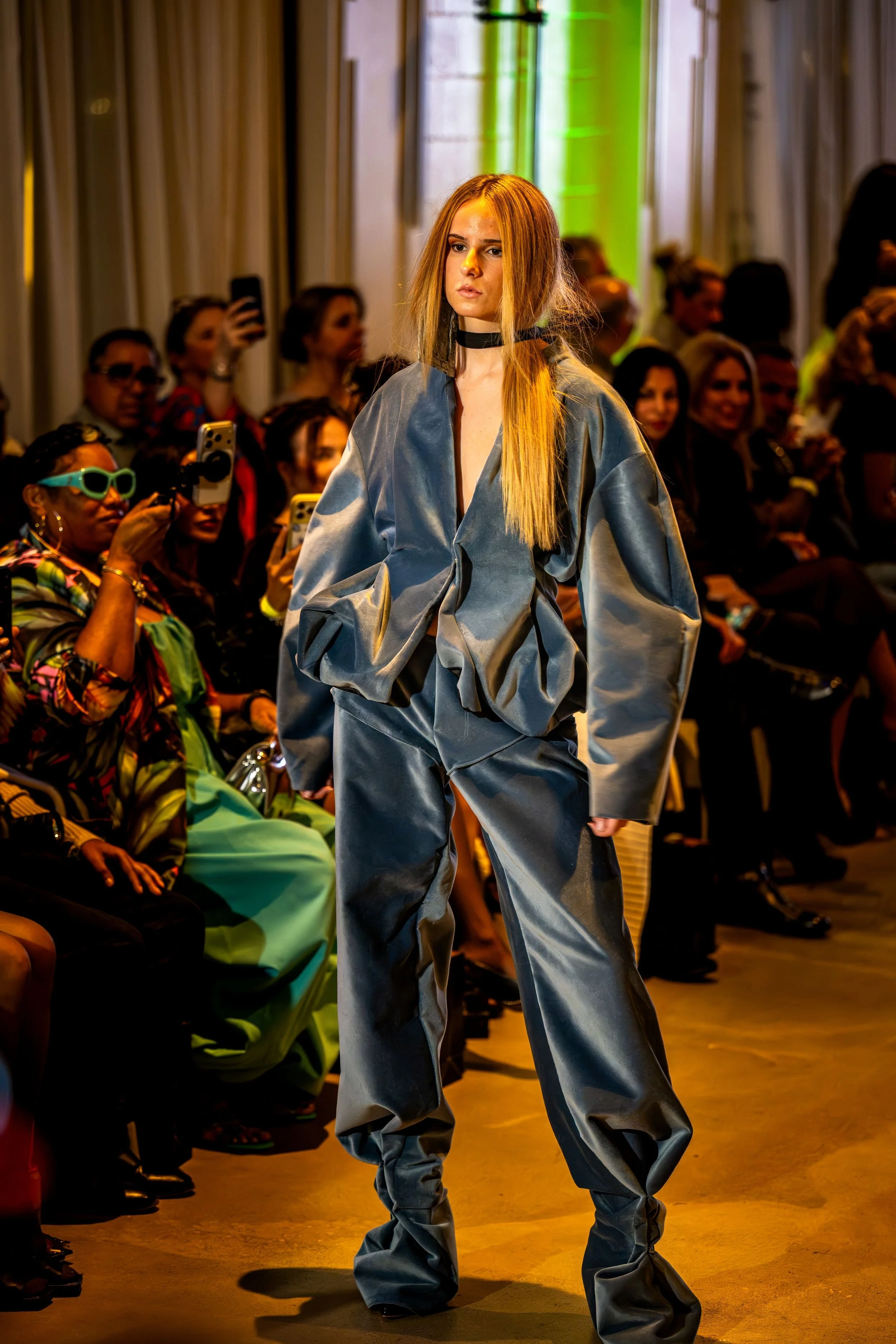 Model wearing a sculptural blue suit on the runway at Charlotte Fashion Week