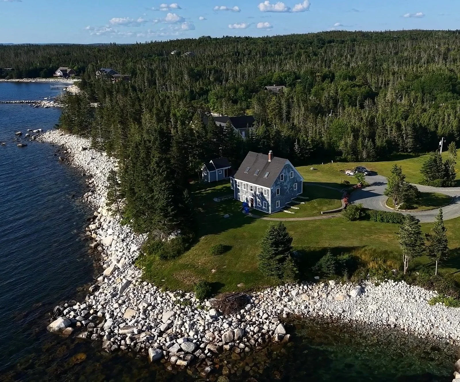 A blue shingled Cape-style home on its own point in Hacketts Cove, St. Margarets Bay