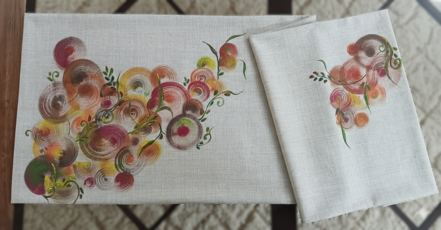 Decorative table runner with a colorful spiral and swirl pattern on two pieces of fabric, featuring shades of pink, orange, yellow, green, and brown.