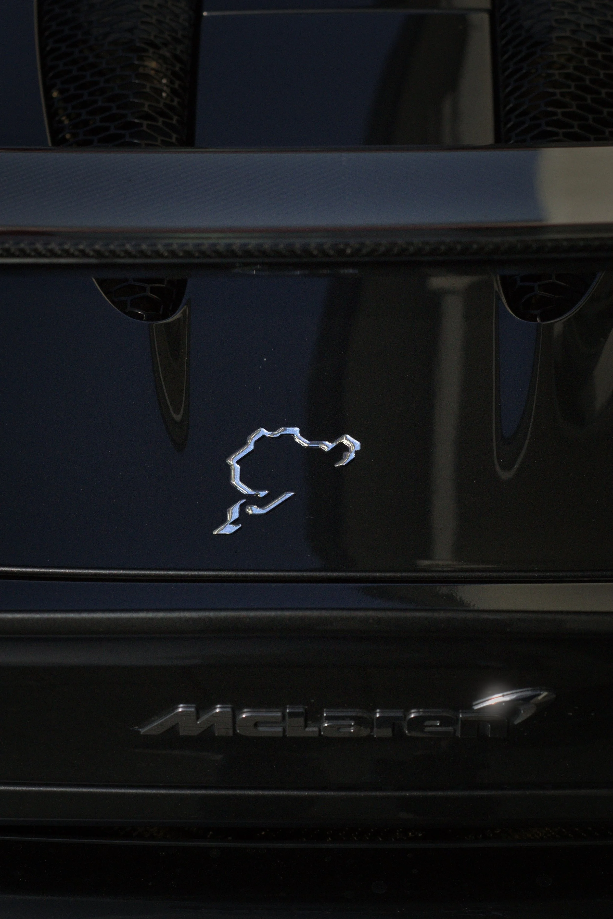 Vorderseite eines schwarzen McLaren Autos mit silbernem McLaren Logo.