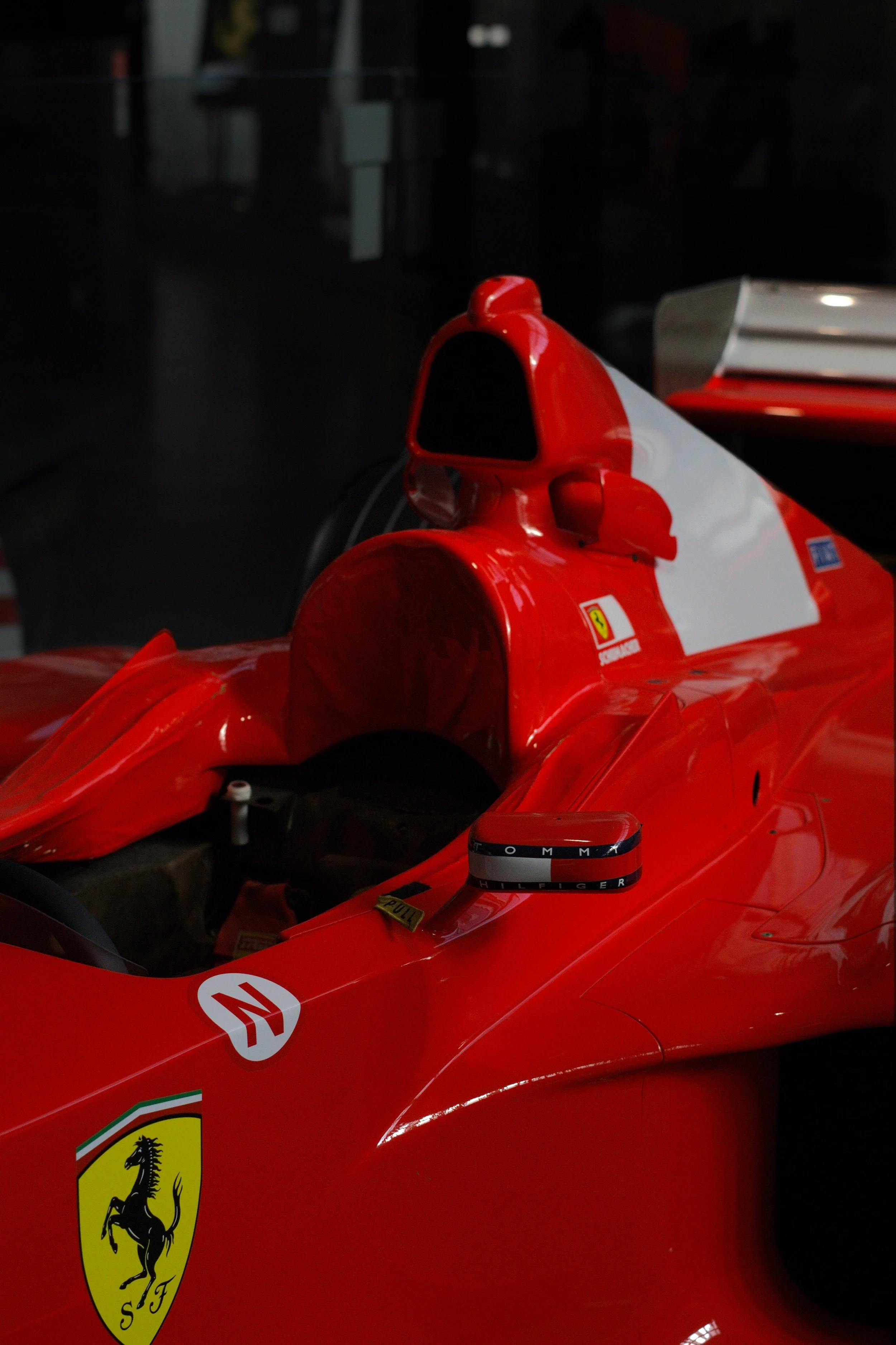 Rotes Ferrari Formel 1 Rennwagen im Museum, sichtbare Ferrari- und Tommy Hilfiger-Logos.