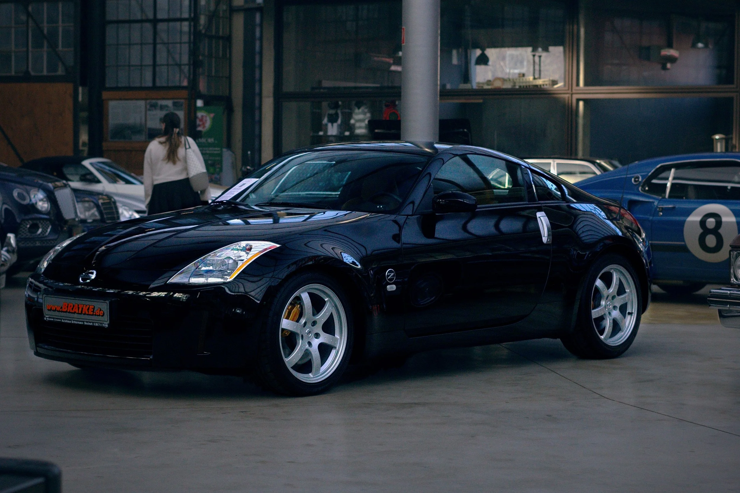 Schwarzer Mazda MX-5 im Autohaus, umgeben von anderen Fahrzeugen.