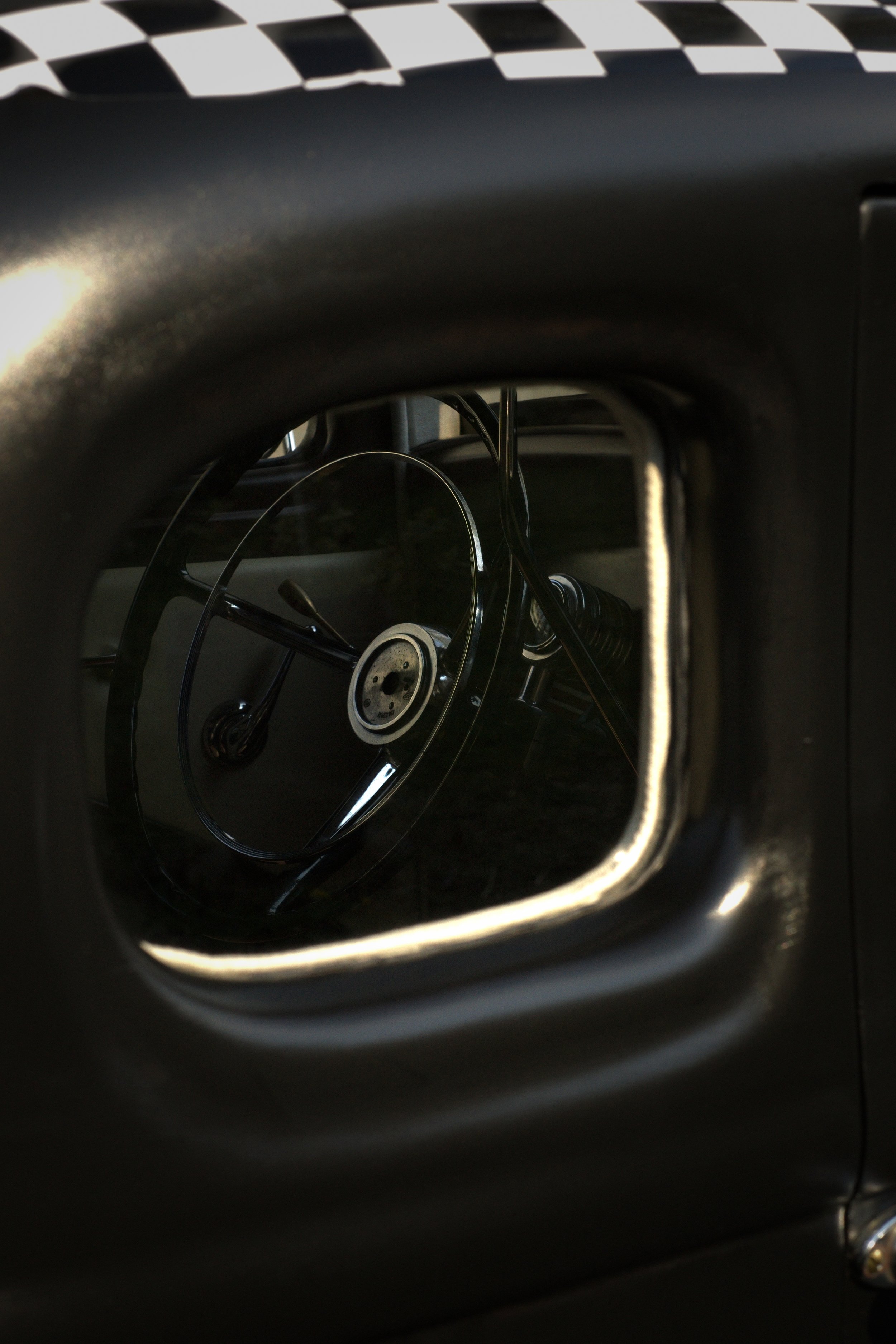 Innenraum eines Autos, Blick durch das Fenster auf das Lenkrad und das Armaturenbrett im Retro-Stil.