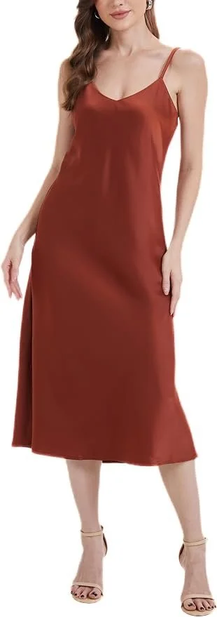 A woman wearing a rust-colored slip dress with spaghetti straps, standing against a plain background.