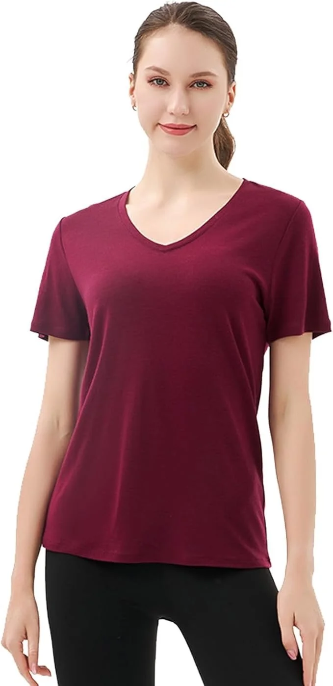 A young woman with light skin, brown hair tied back, is wearing a maroon V-neck T-shirt and black pants, standing against a white background.
