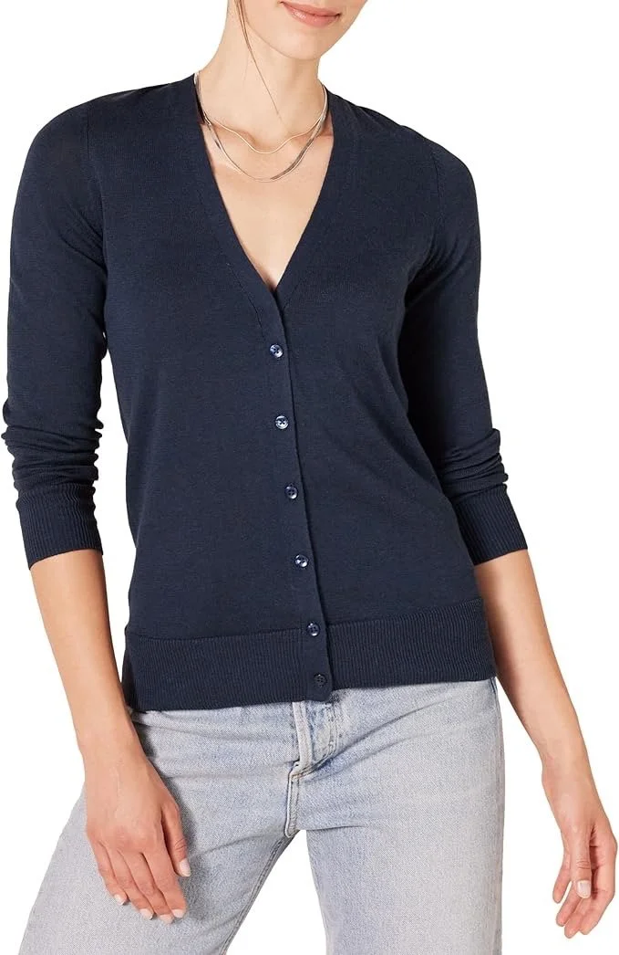 Woman wearing a navy blue V-neck cardigan with buttons and light gray jeans.
